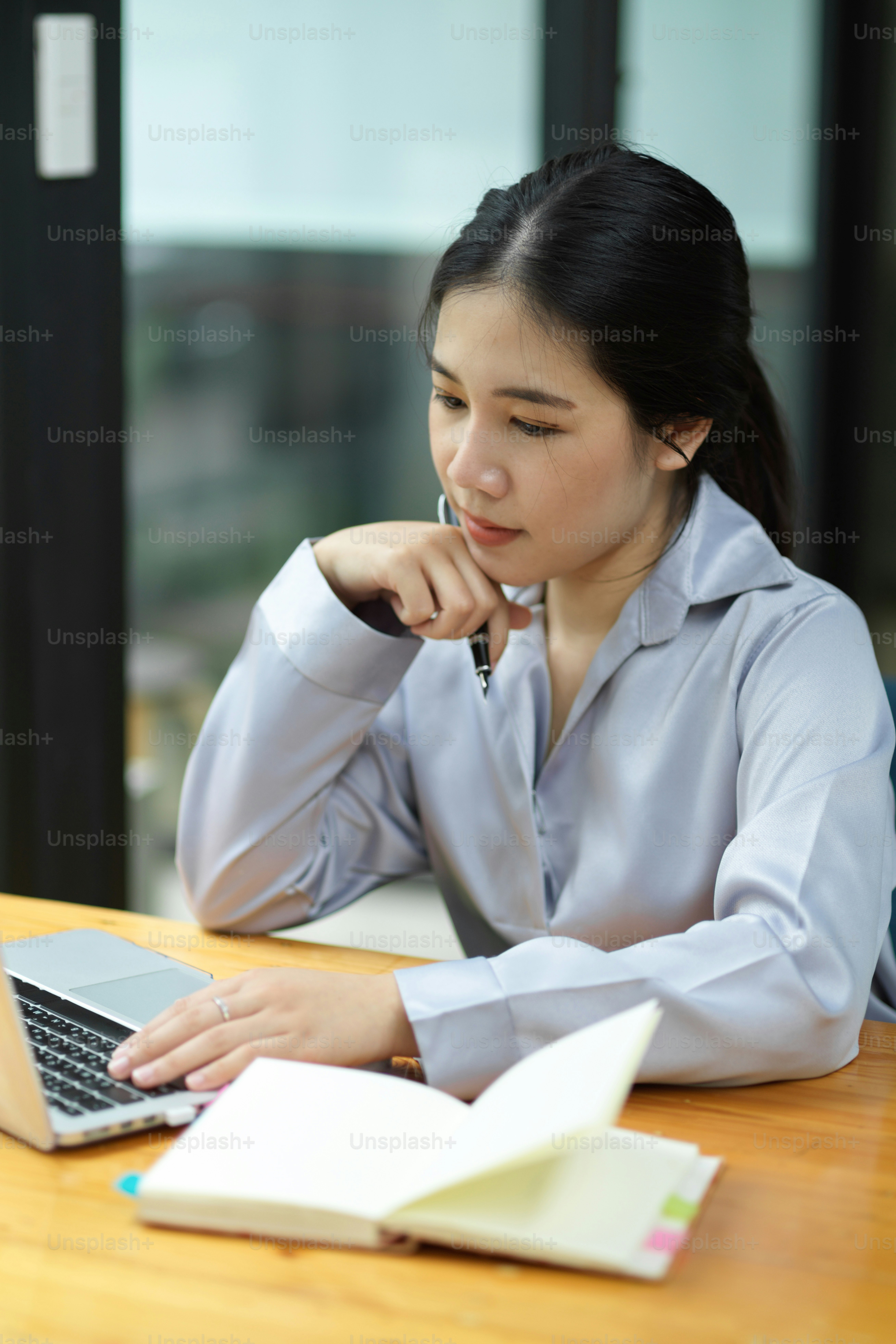Portrait of Thoughtful asian businesswoman working and analysing business financial statement on laptop computer.
